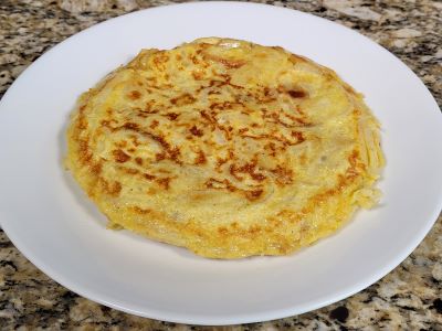 Spanish omelette cooked and displayed on a white plate.